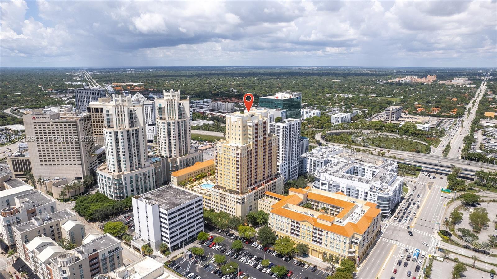 An aerial view shows a tall, tan residential building marked with a red location pin — 7350 SW 89th St # 1410S, Miami FL 33156, MIAMI, FL