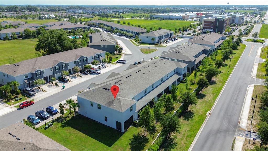 An aerial view shows a multi-unit townhouse complex with a red location marker on a roof — 5311 DRAGONFLY DRIVE, WILDWOOD, FL