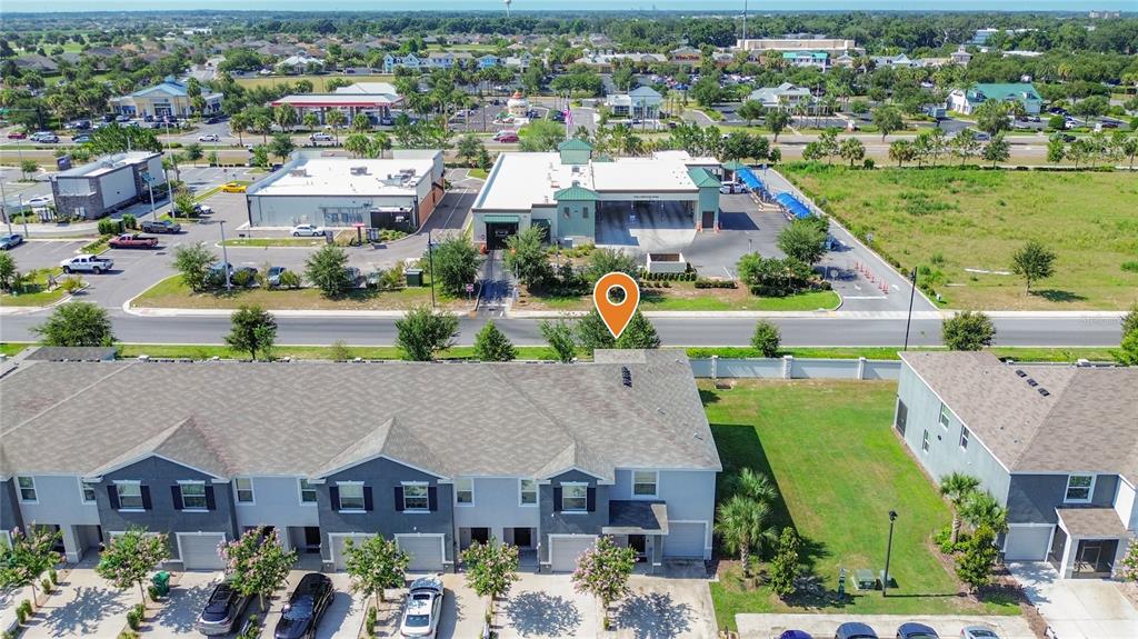 An aerial view shows a multi-unit townhouse complex with a nearby commercial car wash — 5311 DRAGONFLY DRIVE, WILDWOOD, FL