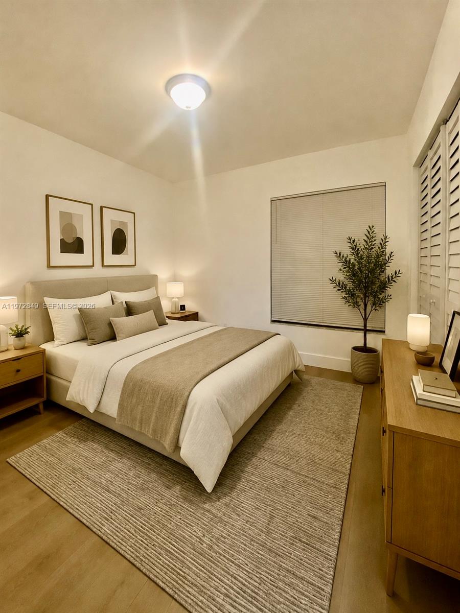 A bedroom features a queen bed, neutral bedding, two framed prints, and a wooden dresser — 1765 Courtyard way # 103, Naples FL 33114, NAPLES, FL