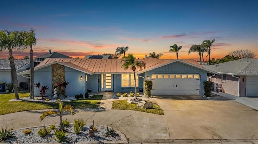 A single-story blue house with a metal roof, palm trees, and a concrete driveway — 5001 MARLIN DRIVE, NEW PORT RICHEY, FL