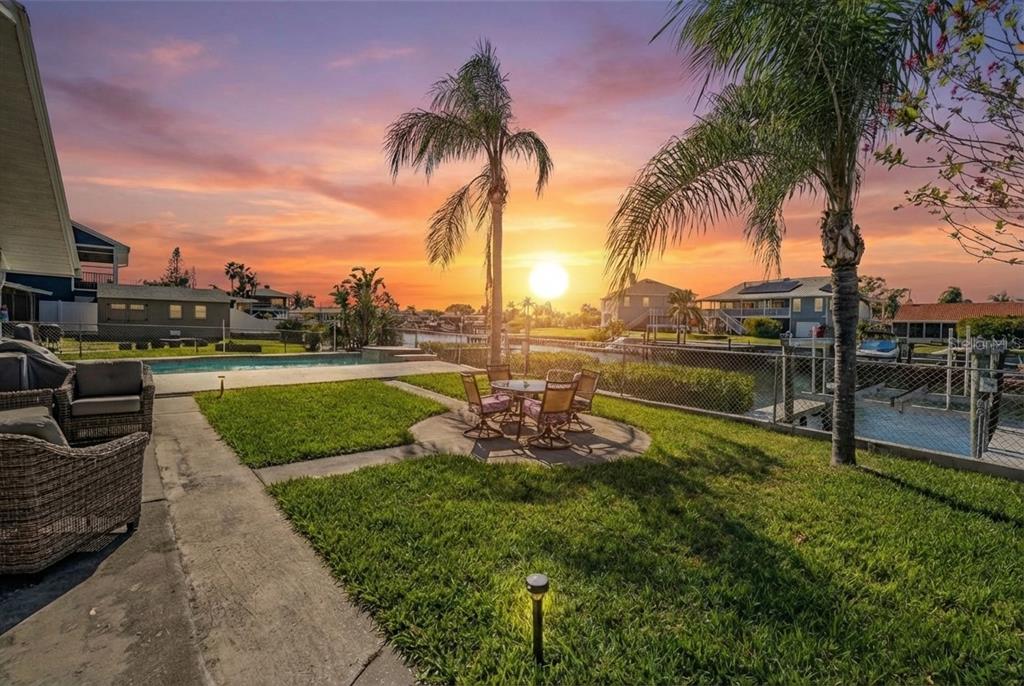 An aerial view shows waterfront houses with docks along a canal leading to the bay — 5001 MARLIN DRIVE, NEW PORT RICHEY, FL