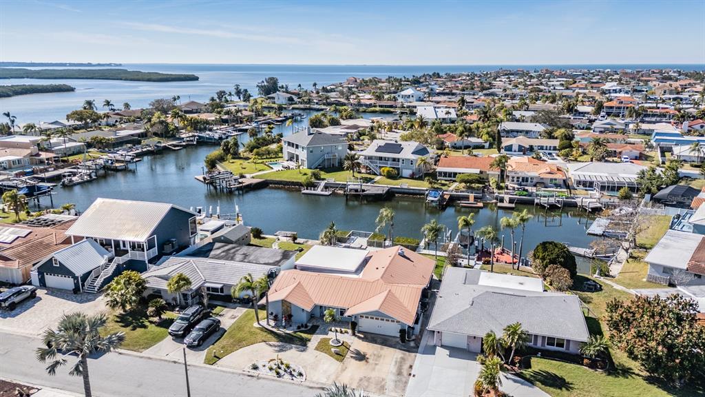An aerial view shows a house with a metal roof, a swimming pool, and a dock — 5001 MARLIN DRIVE, NEW PORT RICHEY, FL