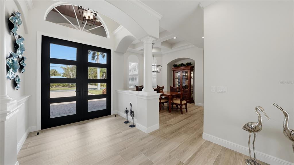 An entryway with light wood-look tile floors leads to a dining area with a hutch — 7637 COVE TERRACE, SARASOTA, FL