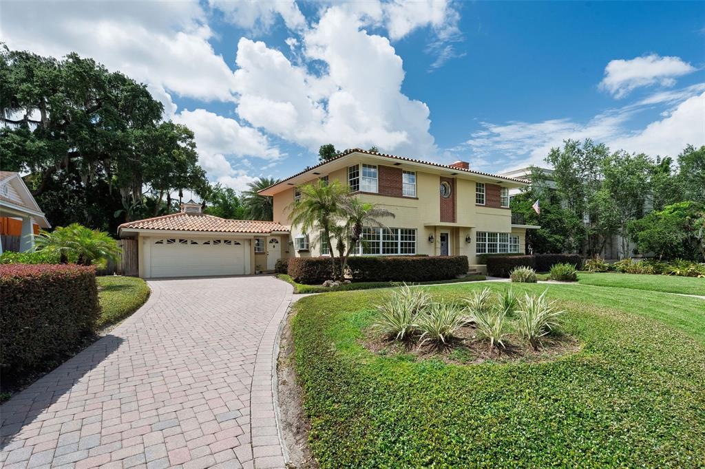 A two-story house with a tile roof, brick accents, and a paved driveway — 830 LAKE DAVIS DRIVE, ORLANDO, FL