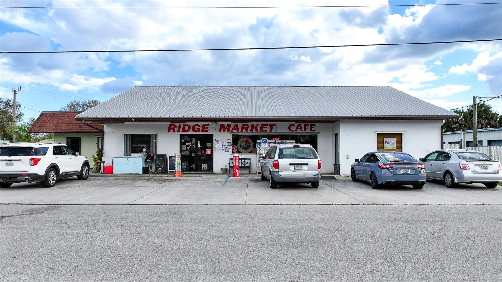 A single-story commercial building with a metal roof and a parking lot in front — 1110 Buckhead Ridge Road, Okeechobee FL 34974, OKEECHOBEE, FL