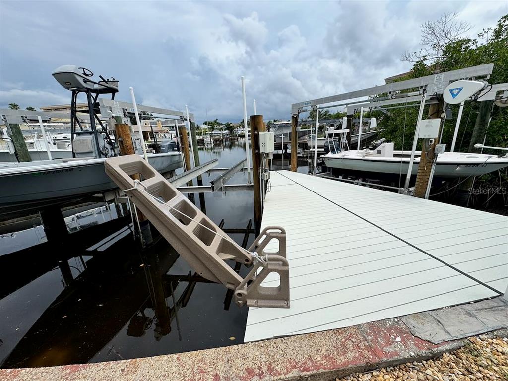 A boat dock with two boat lifts and a white composite deck over water — 5451 BAYOU GRANDE BOULEVARD NE, ST PETERSBURG, FL