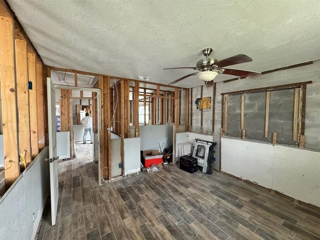 An unfinished room with exposed wall studs, concrete block walls, and wood-look tile flooring — 5451 BAYOU GRANDE BOULEVARD NE, ST PETERSBURG, FL