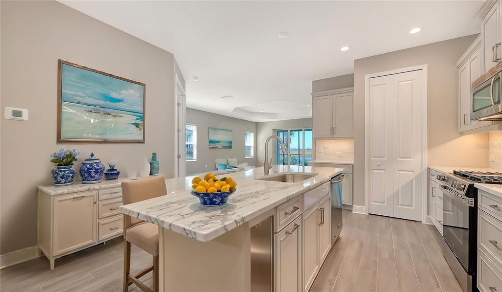 A kitchen with a marble-topped island, light cabinetry, and stainless steel appliances — 2118 SYLVESTER PALM LANE, BRADENTON, FL