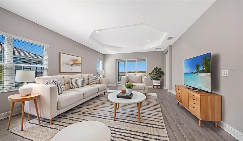 A living room features a beige sofa, a white coffee table, and a television console — 2118 SYLVESTER PALM LANE, BRADENTON, FL