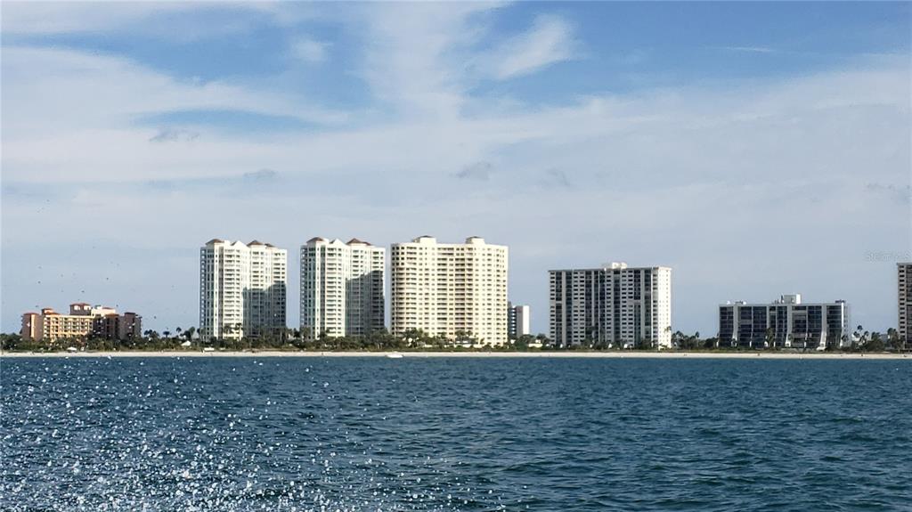 A view of several high-rise residential buildings along a sandy beach and the ocean — 1230 GULF BOULEVARD UNIT 1404, CLEARWATER, FL