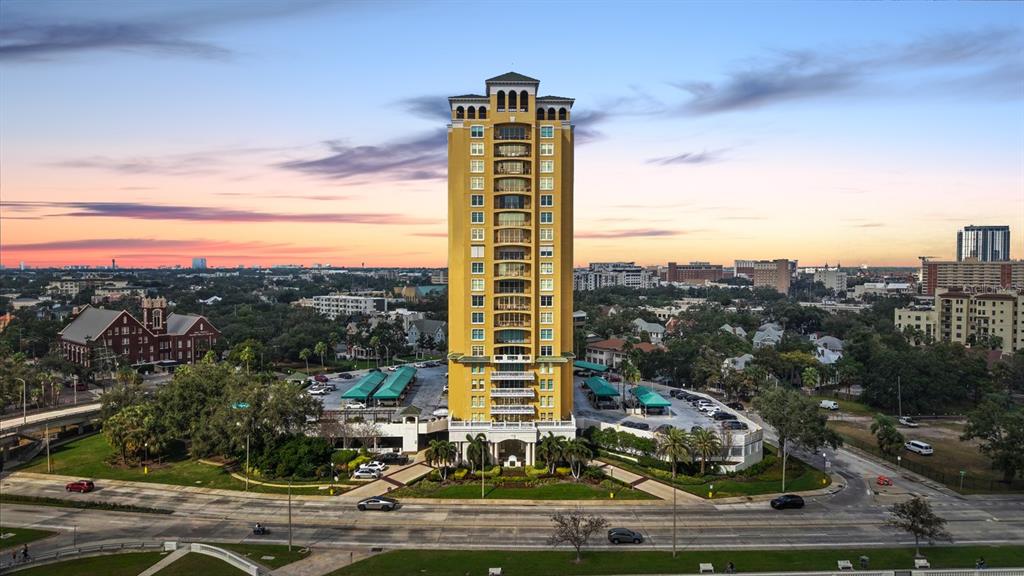 An aerial view shows a tall, yellow residential tower surrounded by parking and city streets — 345 BAYSHORE BOULEVARD UNIT 706, TAMPA, FL