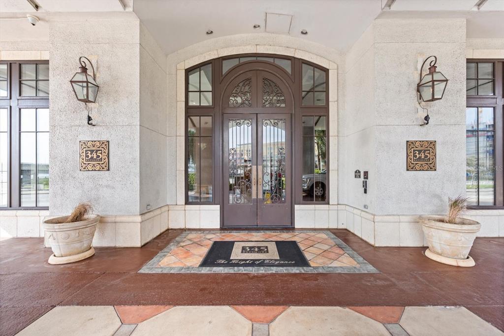 The exterior entrance features double glass doors, decorative wall plaques, and two large stone planters — 345 BAYSHORE BOULEVARD UNIT 706, TAMPA, FL