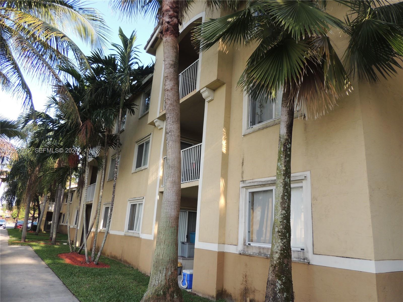 A kitchen with white cabinets and appliances opens into a tiled dining area — 2600 S University Dr # 103, Davie FL 33328, DAVIE, FL