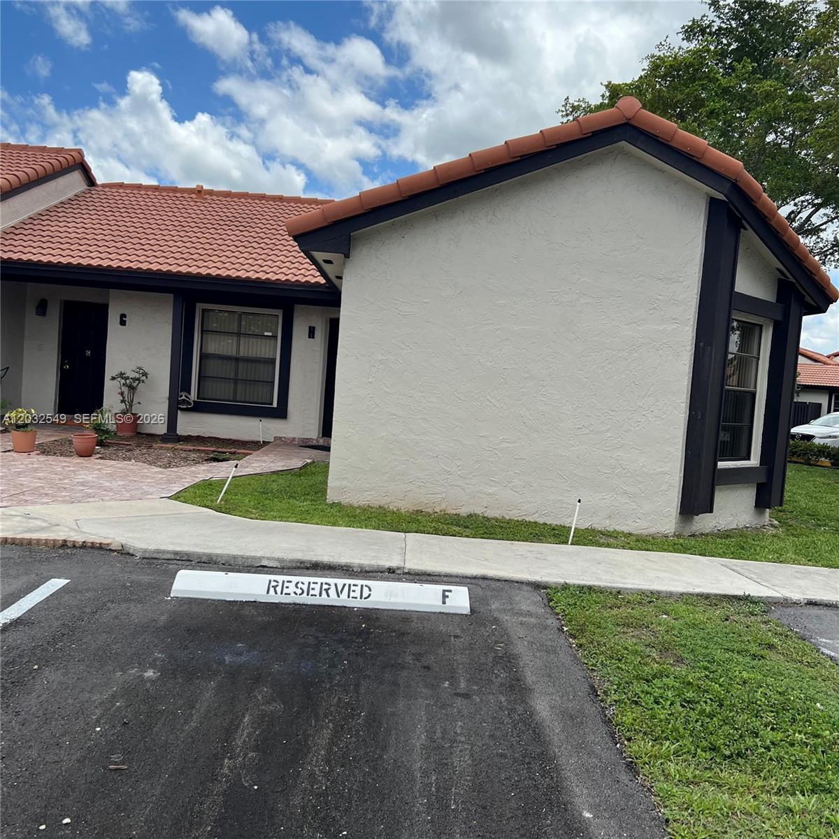 A single-story residential building with a tiled roof and a reserved parking space — 15272 SW 46th Ln # 66, Miami FL 33185, MIAMI, FL
