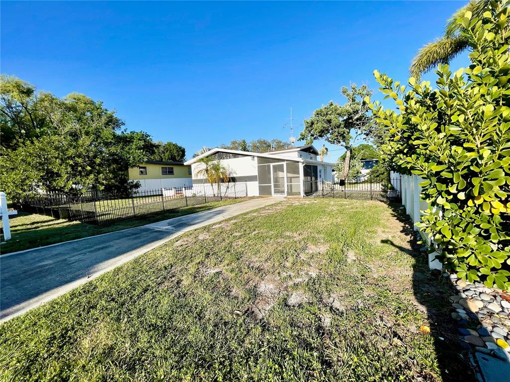 A single-story house with a screened porch and a long driveway sits on a grassy lot — 4608 S HESPERIDES STREET, TAMPA, FL