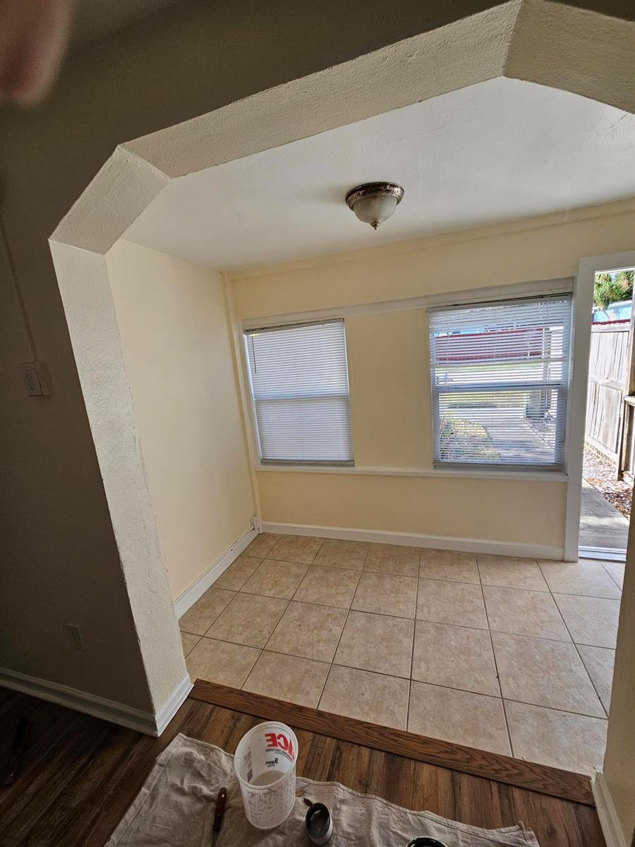 A sunroom with tile flooring, two windows with blinds, and a door leading outside — 115 E Palm Street E # 117, Lantana FL 33462, LANTANA, FL