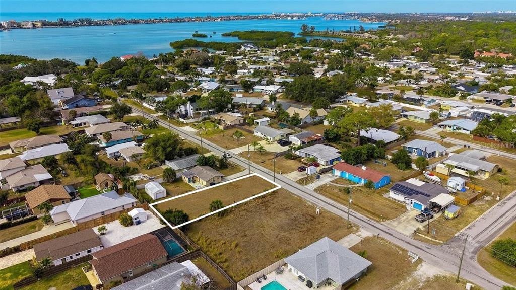 An aerial view shows a vacant rectangular lot situated in a residential neighborhood near water — 0 (Lot 15) WHARF ROAD, SARASOTA, FL