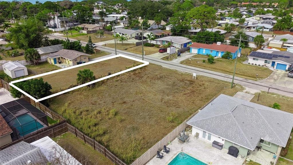 An aerial view shows a vacant rectangular lot outlined in white between two residential houses — 0 (Lot 15) WHARF ROAD, SARASOTA, FL