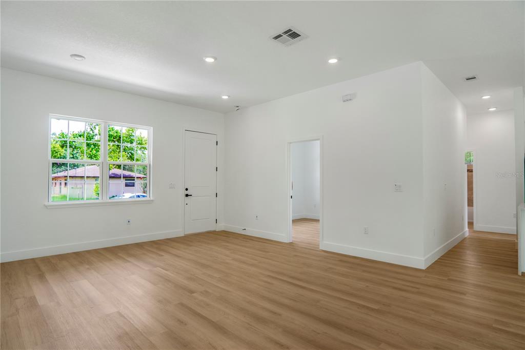 An empty room with light wood-look flooring, white walls, recessed lighting, and a window — 8383 N IBSEN DRIVE, CITRUS SPRINGS, FL