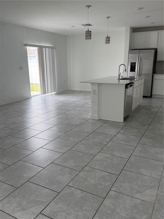 A kitchen with a white island, stainless steel appliances, and gray tile flooring — 598 BELL PRAIRIE CIRCLE, LAKE WALES, FL