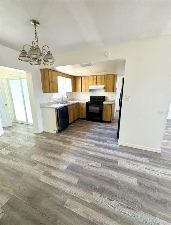 A kitchen with wood cabinets, stainless steel appliances, and wood-look flooring — 8151 HIXTON DRIVE, PORT RICHEY, FL