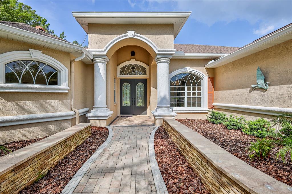 A bright entryway features double glass-paneled doors, tile flooring, and a view into adjacent rooms — 11644 PARABLE COURT, NEW PORT RICHEY, FL