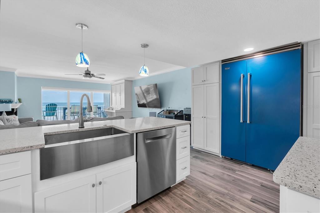 A kitchen features a large stainless steel farmhouse sink, stainless dishwasher, and a blue refrigerator — 20204 GULF BOULEVARD UNIT 3, INDIAN SHORES, FL