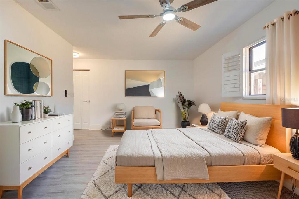 A bedroom features a light wood bed frame, white dresser, armchair, and a ceiling fan — 2261 S FLAGLER AVENUE, FLAGLER BEACH, FL