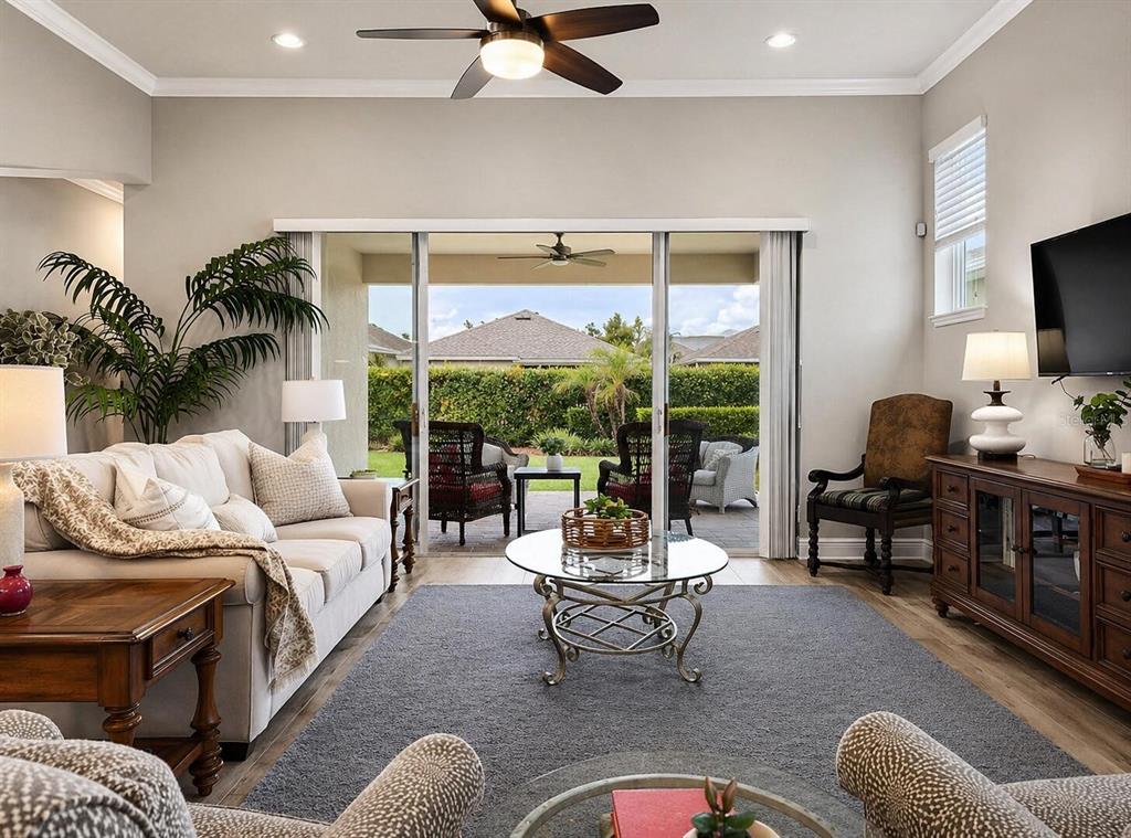 A living room features a beige sofa, glass coffee table, and sliding doors to a patio — 13928 SWALLOW HILL DRIVE, LITHIA, FL