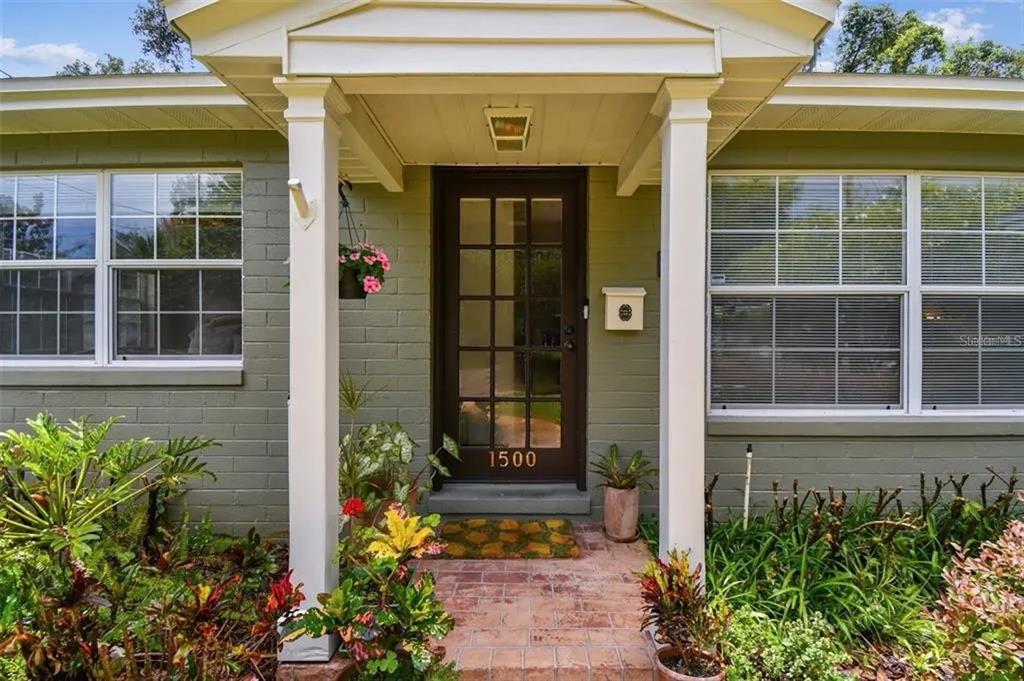 A front porch with white columns leads to a dark brown glass-paneled door — 1500 E RIDGEWOOD STREET, ORLANDO, FL