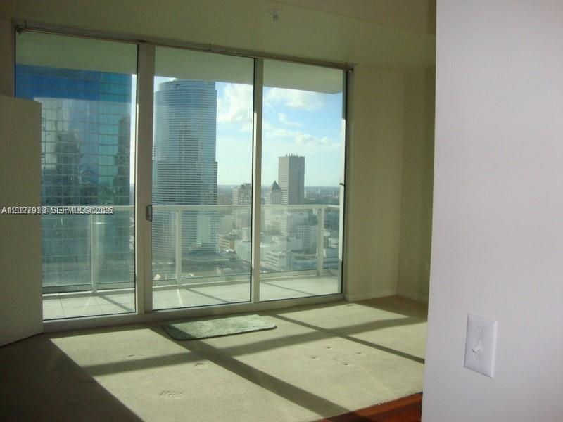 A room with beige carpeting and floor-to-ceiling windows overlooking a city skyline — 300 S Biscayne Blvd # 2909, Miami FL 33131, MIAMI, FL