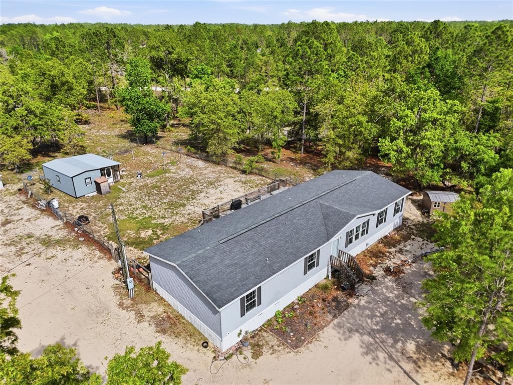 An aerial view shows a single-story manufactured home with a deck and a detached garage — 2640 NE 74TH AVENUE, HIGH SPRINGS, FL
