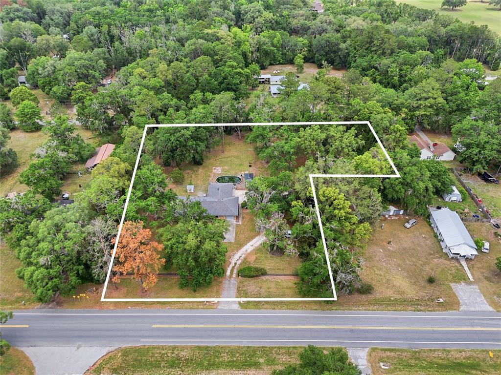 An aerial view shows a house with a pool on a large, wooded lot — 4803 W STATE ROAD 238, LAKE BUTLER, FL