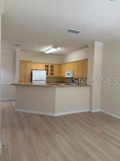 A kitchen with light wood cabinets, a breakfast bar, and light-colored wood-look flooring — 3707 CONROY ROAD UNIT 1713, ORLANDO, FL