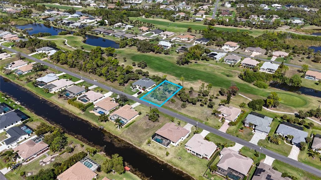 An aerial view shows a vacant residential lot highlighted in blue within a suburban neighborhood — 242 MARKER ROAD, ROTONDA WEST, FL