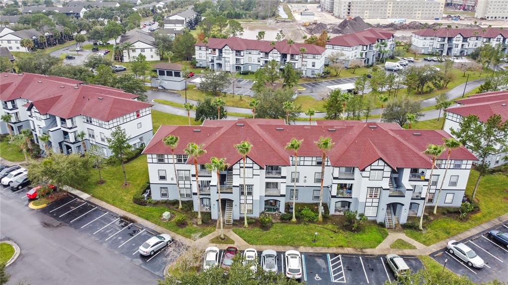 An aerial view shows several multi-story apartment buildings with red roofs and parking lots — 5525 PGA BOULEVARD SW UNIT 4625, ORLANDO, FL