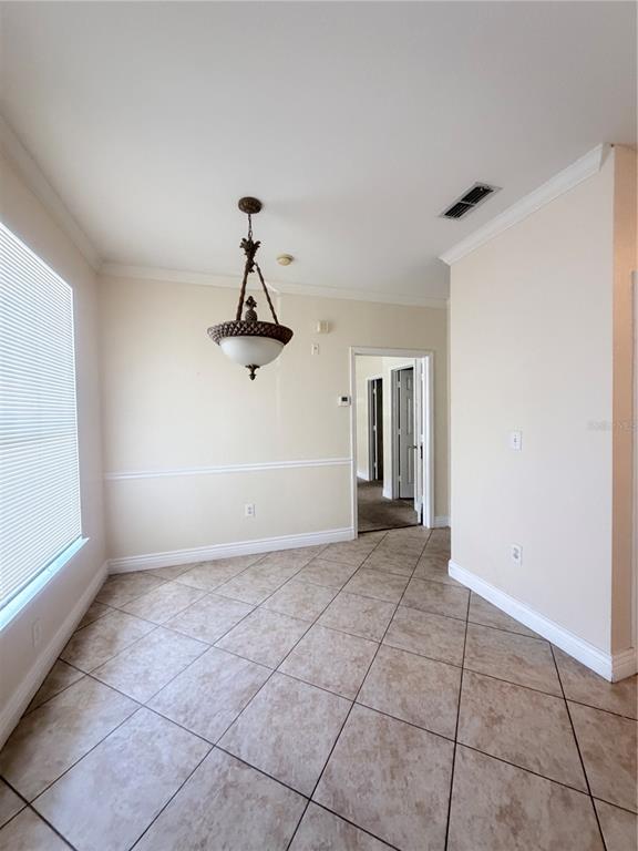 A dining area with tile flooring, a decorative chandelier, and a doorway leading to hallways — 5525 PGA BOULEVARD SW UNIT 4625, ORLANDO, FL