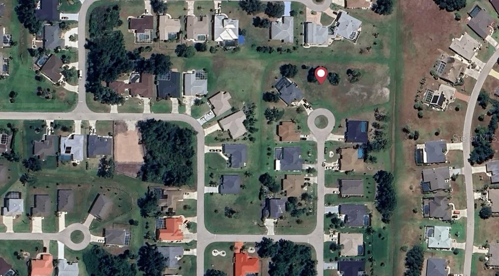This aerial view shows a vacant residential lot marked with a red pin in a neighborhood — 41 RIO CUARTO STREET, PUNTA GORDA, FL