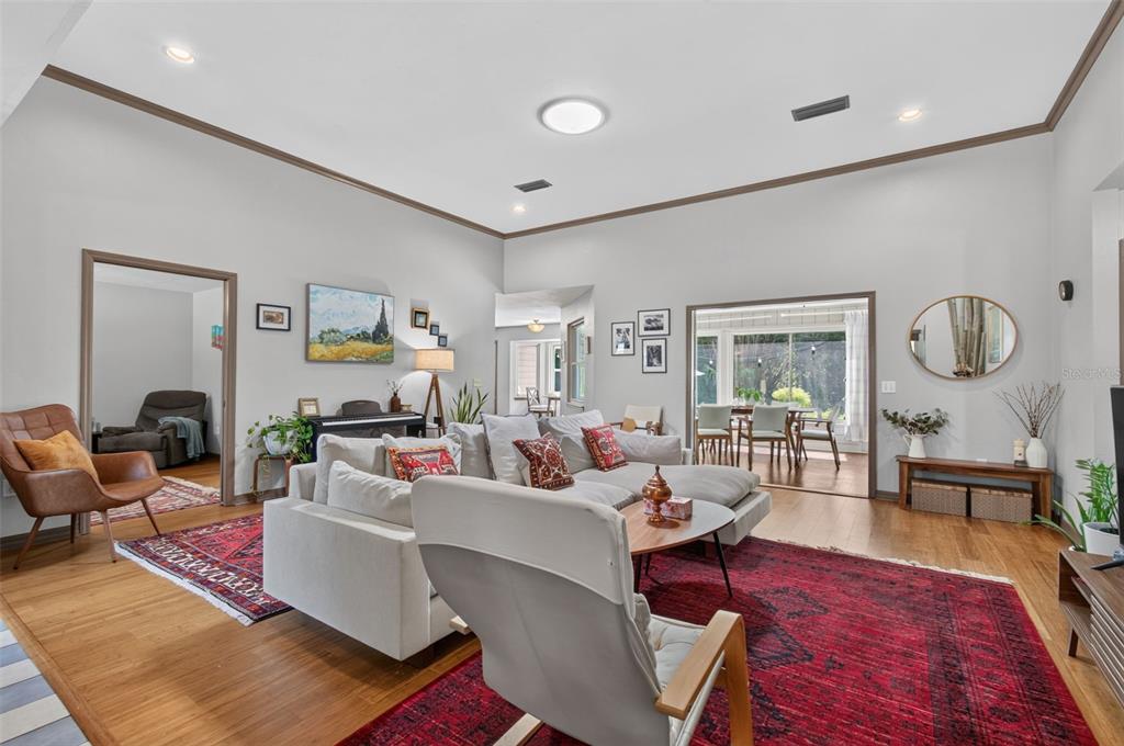 A living room features a sectional sofa, red area rugs, and hardwood floors — 2840 NW 27TH TERRACE, GAINESVILLE, FL