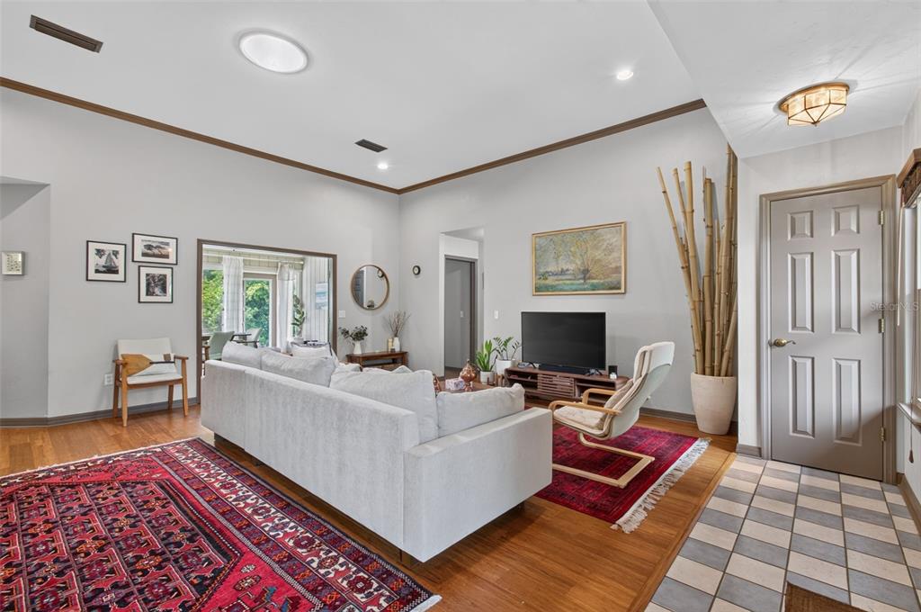 A living room features a light gray sofa, red area rugs, and bamboo decor — 2840 NW 27TH TERRACE, GAINESVILLE, FL