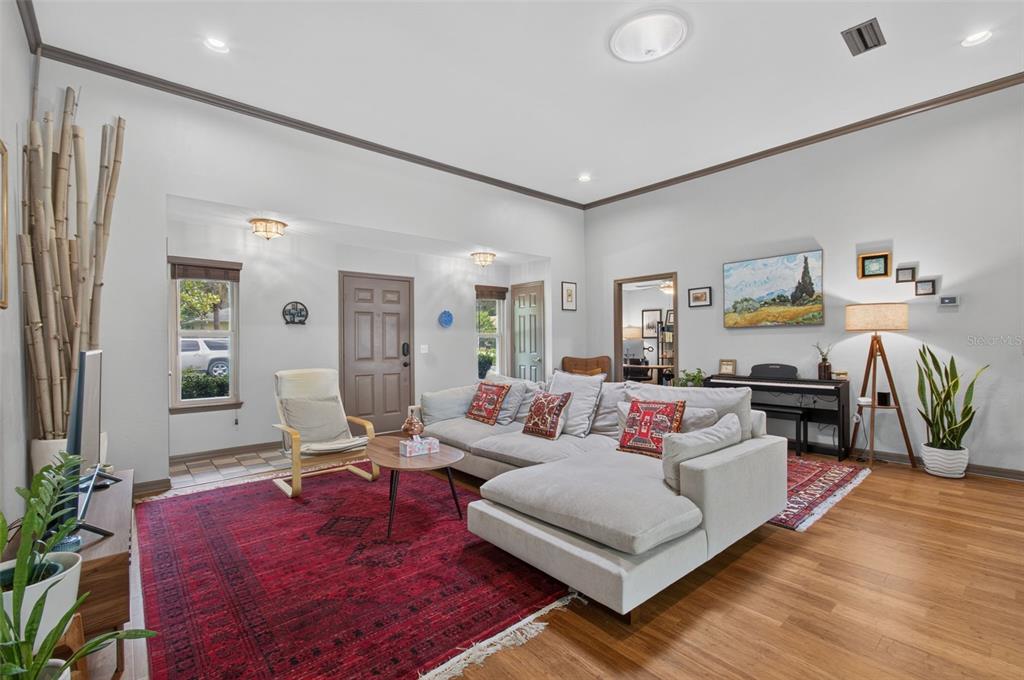 A living room features a large sectional sofa, a red rug, and hardwood floors — 2840 NW 27TH TERRACE, GAINESVILLE, FL