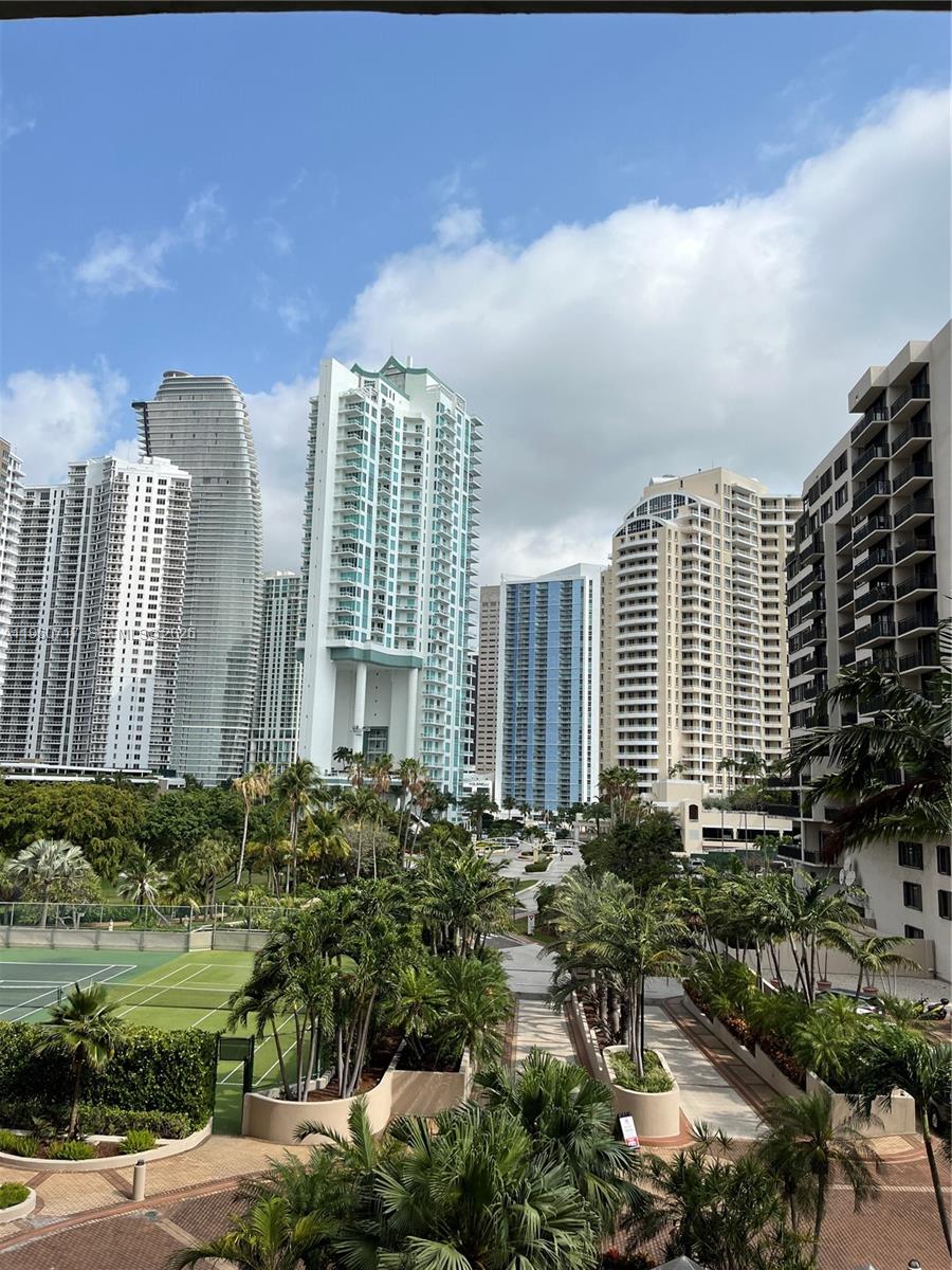 An elevated view of a tennis court surrounded by palm trees and several high-rise buildings — 520 Brickell Key Dr # A610, Miami FL 33131, MIAMI, FL