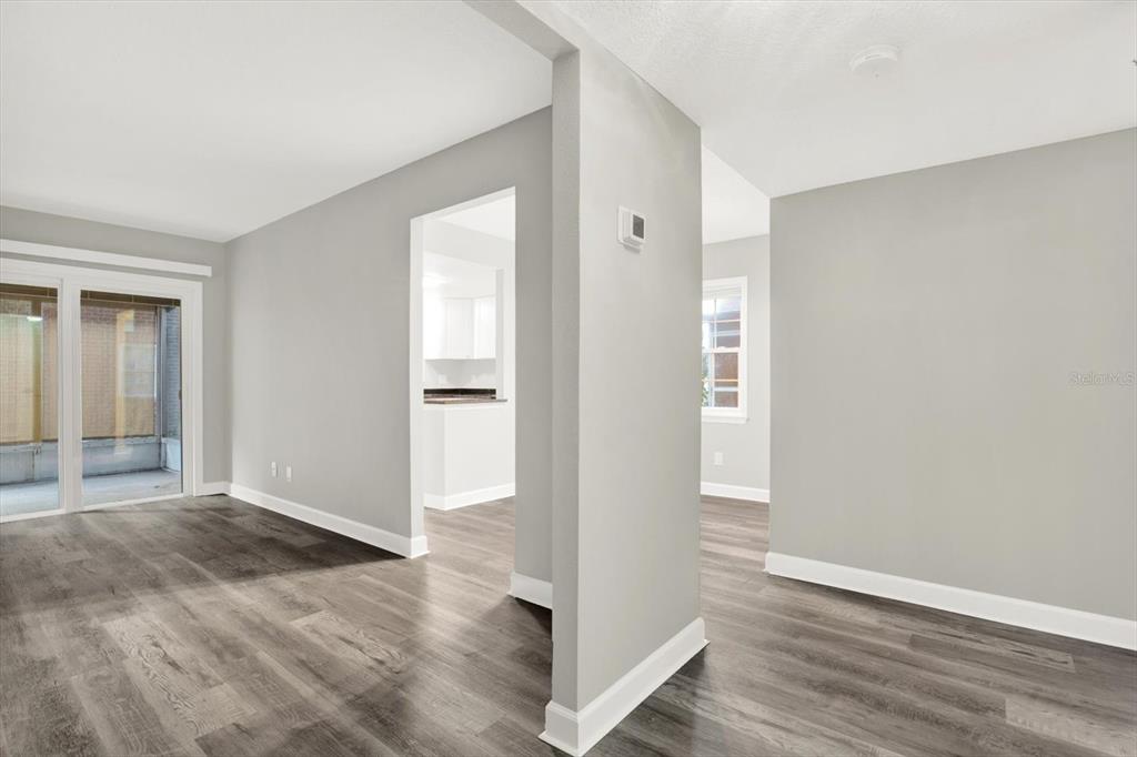 This is a digitally staged living room with a sofa, armchair, coffee table, and television — 8345 13TH STREET N UNIT B, ST PETERSBURG, FL