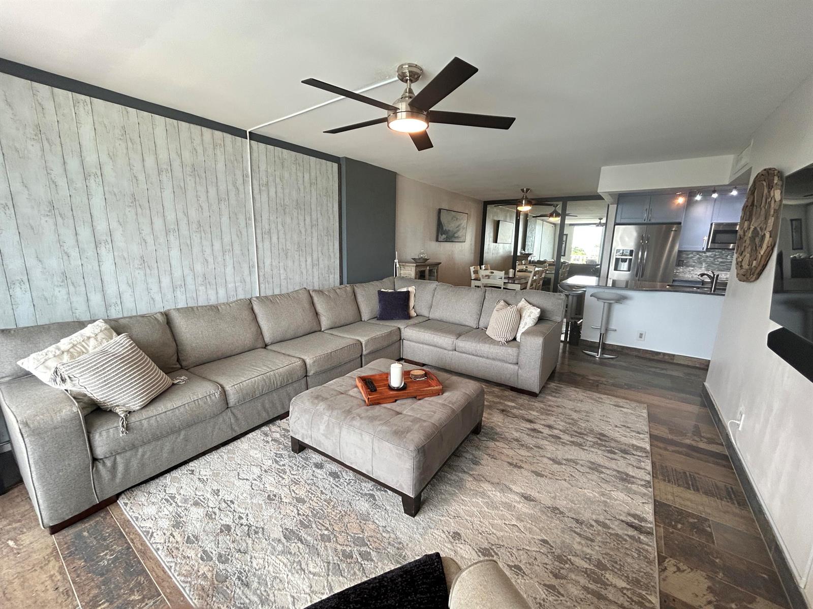 A living room features a large grey sectional sofa, a matching ottoman, and a ceiling fan — 1009 N Ocean Boulevard N # 401, Pompano Beach FL 33062, POMPANO BEACH, FL