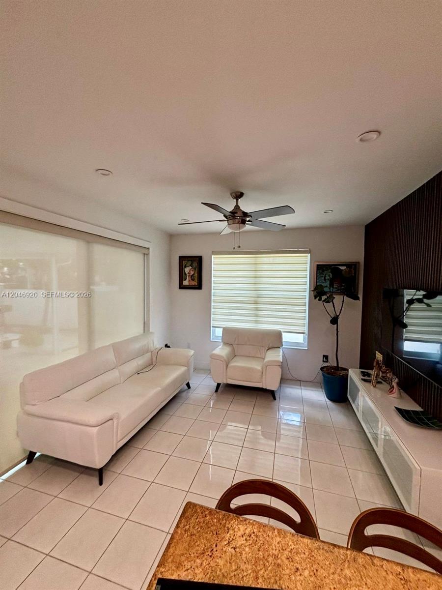A living room features white tile floors, a white sofa, an armchair, and a ceiling fan — 15986 SW 71st Ter, Miami FL 33193, MIAMI, FL