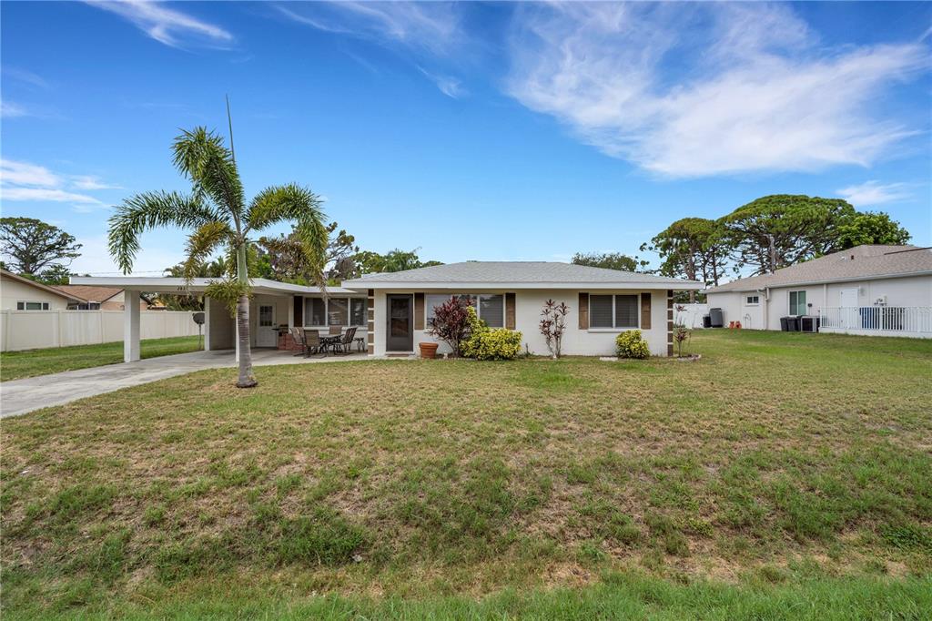 A single-story house with a carport, a palm tree, and a large front lawn — 2830 SIESTA DRIVE, VENICE, FL