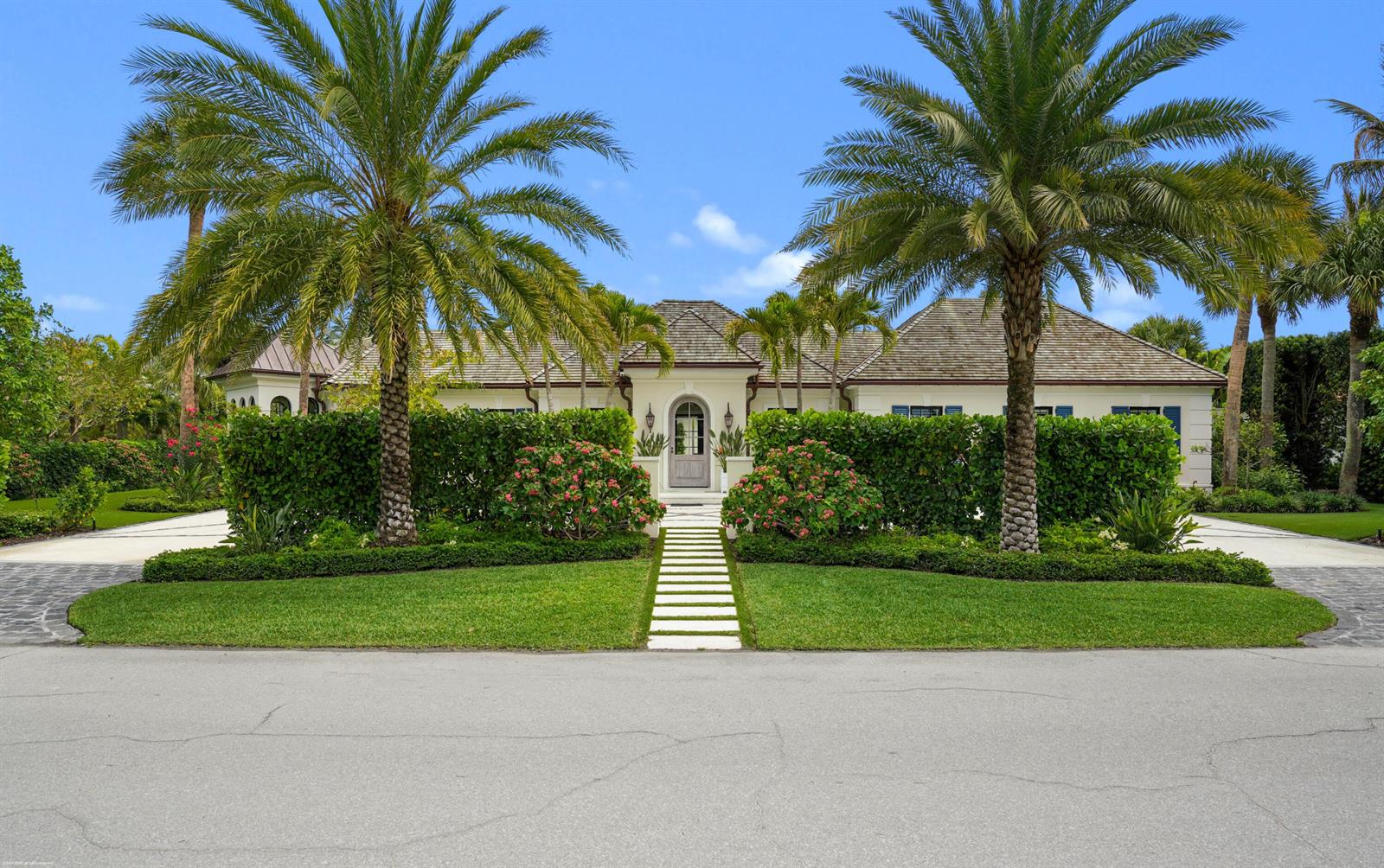 A single-story house with a white exterior, palm trees, and a stone walkway in front — 55 Links Road, Jupiter Island FL 33455, JUPITER ISLAND, FL