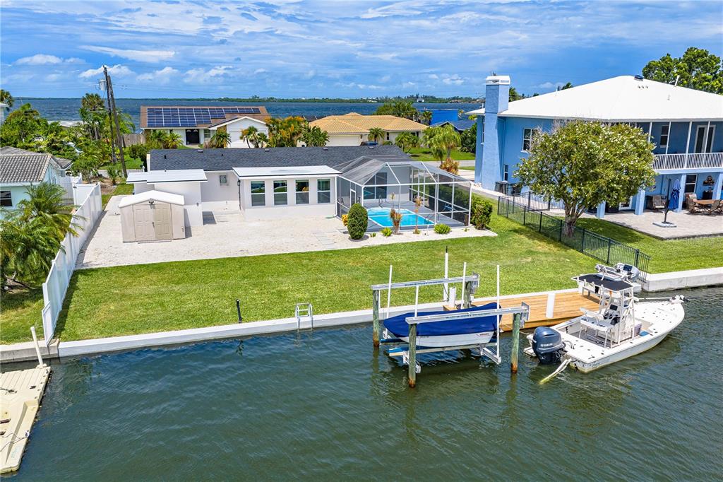 An aerial view of a waterfront home featuring a pool, boat lift, and private dock — 5004 ARLINGTON ROAD, PALMETTO, FL
