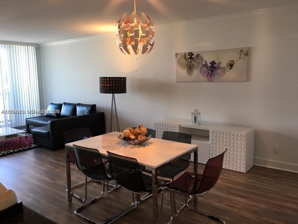 A dining area features a white table, modern chairs, a pendant light, and a sideboard — 401 69th St # 905, Miami Beach FL 33141, MIAMI BEACH, FL